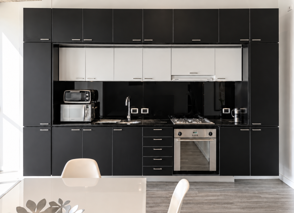 Cocina negra lineal con electrodomésticos integrados